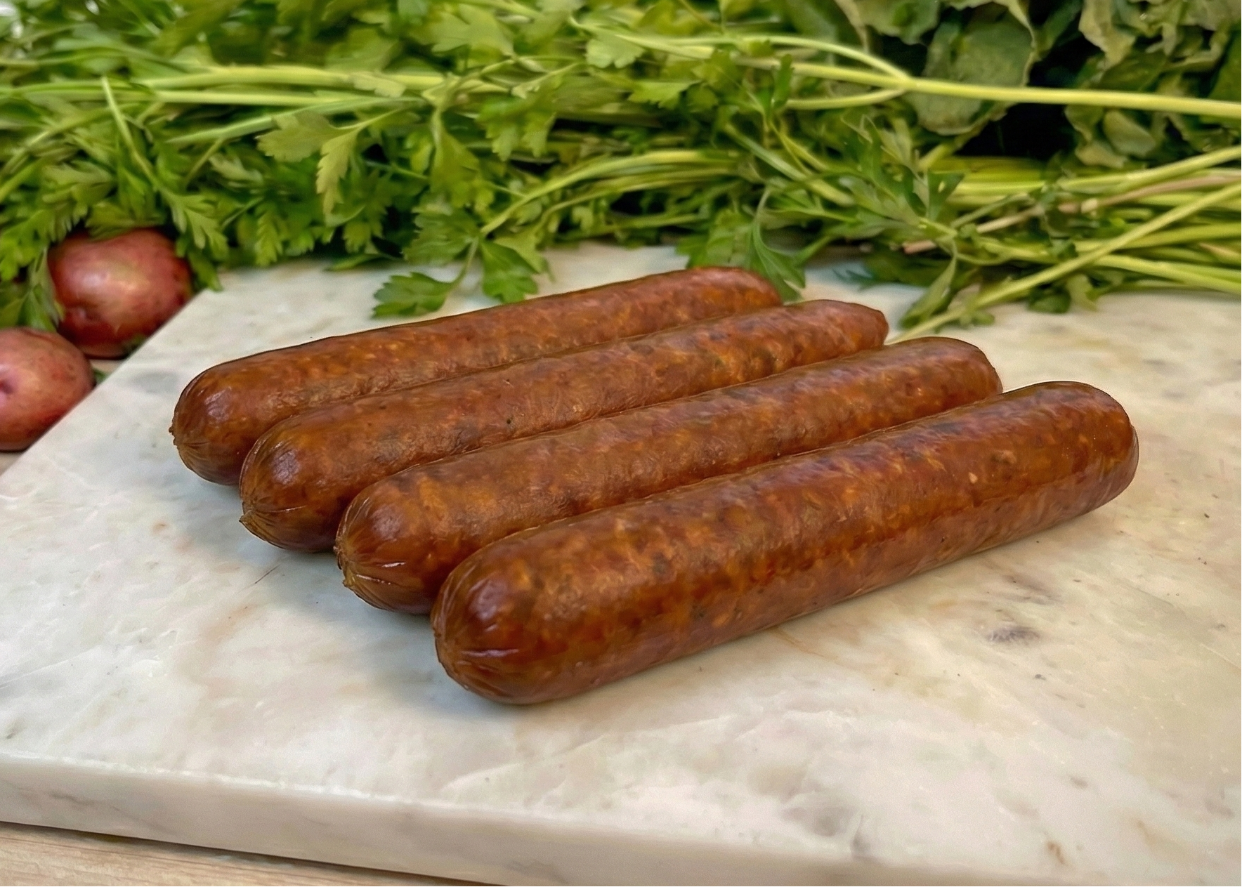 Buffalo Thin Franks on a cutting board with greens and onions in the background