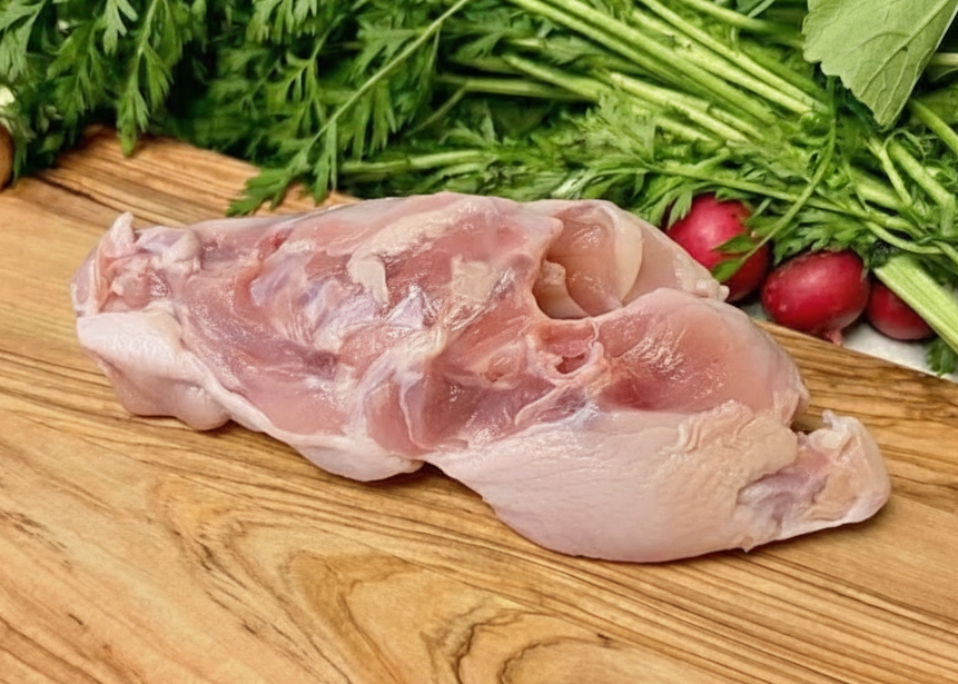 Raw Omega-3 Chicken Soup Bones on a wooden cutting board with fresh vegetables