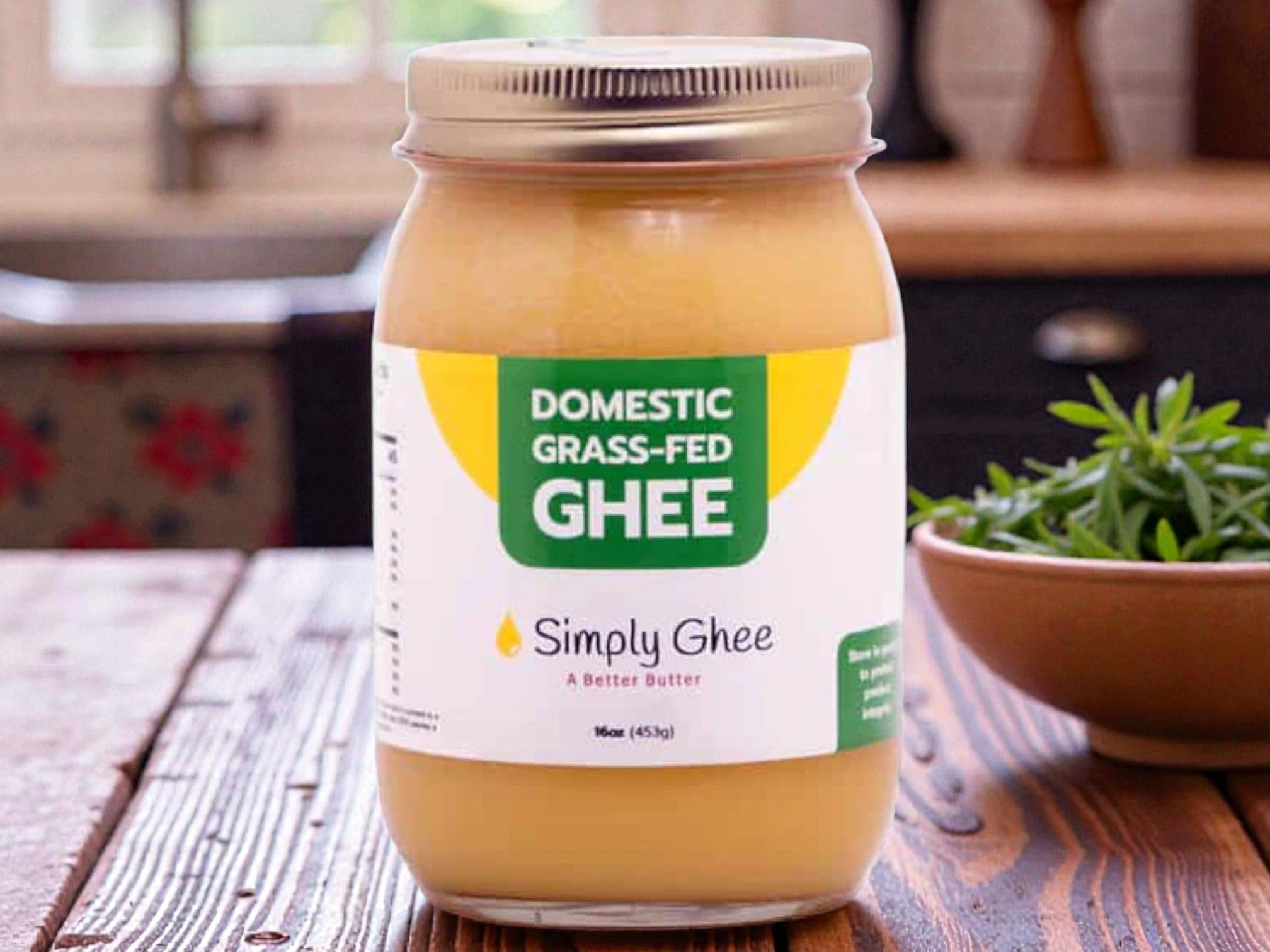 Jar of Domestic Grass-Fed Ghee on a wooden table with a kitchen background
